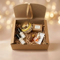 Six-item Bath & Fragrance Gift Set against a celebratory champagne-gold and blush background with warm golden lights