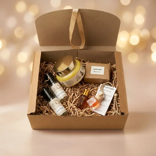 Six-item Bath & Fragrance Gift Set against a celebratory champagne-gold and blush background with warm golden lights